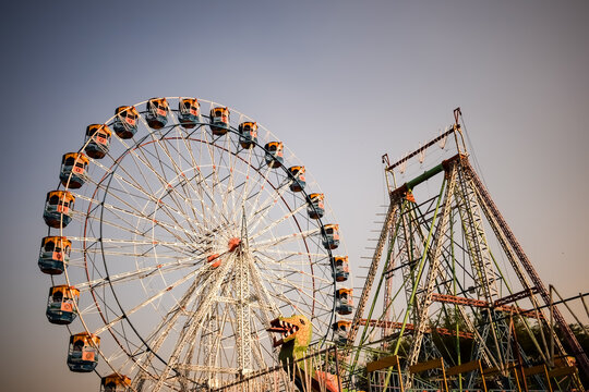 Closeup of multi-coloured Giant Wheel during Dussehra Mela in Delhi, India. Bottom view of Giant Wheel swing. Ferriswheel with colourful cabins during day time.