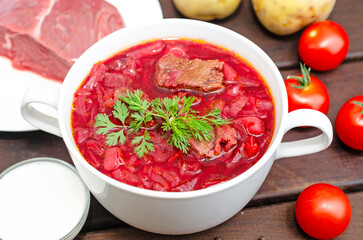Borscht soup with vegetables and meat on a wooden table