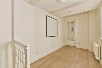 an empty room with white walls and hardwood flooring on the right hand side, there is a staircase leading up to the second