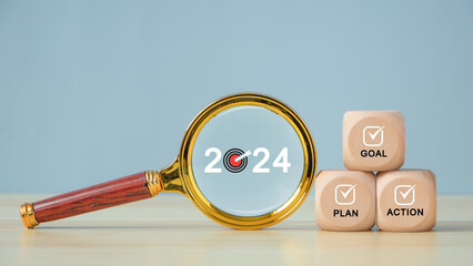 2024 Business target and action plan strategy. Magnifying glass with text 2024 and wooden cubes...