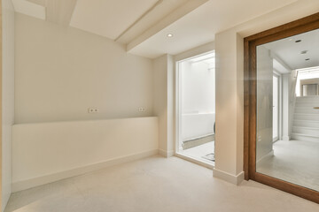 an empty room with a mirror on the wall and door to another room in the same area, as well
