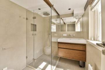 a bathroom with a sink, toilet, and shower stall in the same photo is taken from the other side