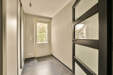 a hallway in a house with white walls and black trim on the door, there is an entry way that leads...
