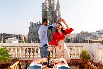 Foto op Canvas Multiracial beautiful happy couple of lovers dating on rooftop balcony at Sagrada Familia, Barcelona - Multiethnic people having romantic aperitif dinner on a terrace with city view  © oneinchpunch
