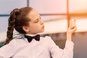 Portrait of cute caucasian teen girl holding coin. Saving money concept.