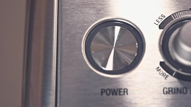 close-up of the buttons of a stainless steel expresso press machine for ground coffee