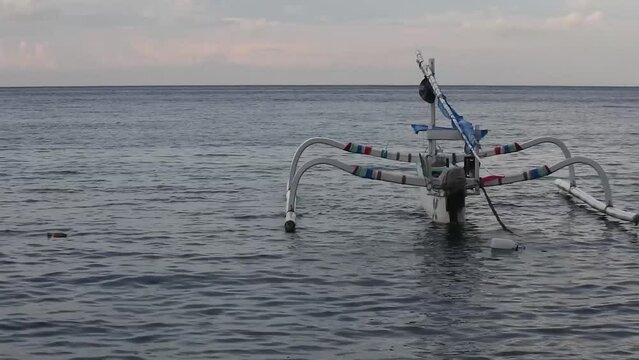 Badik boats float on the waters of Nusa Penida, Bali ahead of sunset. HD videos