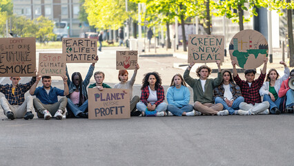 Environmental activists protesting for change - A group of activists gather in an urban setting, holding signs that call for action against climate change. Their placards bear powerful messages. - obrazy, fototapety, plakaty