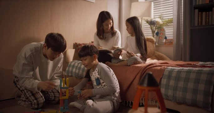 딸과 함께 동화책을 읽는 엄마와 아들과 함께 블록을 쌓아 우주정거장을 만드는 아빠, 줌인 돌리 와이드 샷