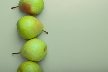 Four fresh green pears on an olive background.Organic healthy food concept.Natural dessert.Fruit background. Place for text, mock-up. - Powered by Adobe