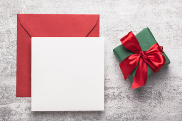 Red envelope and green gift box on a concrete background.Blank form.Greeting card. Place for text.