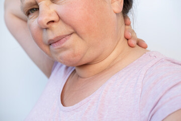 elderly 55s Caucasian woman rubs sore neck, female health concept, herniated intervertebral discs, arthrosis, Myofascial syndrome, dysfunction of intervertebral joints