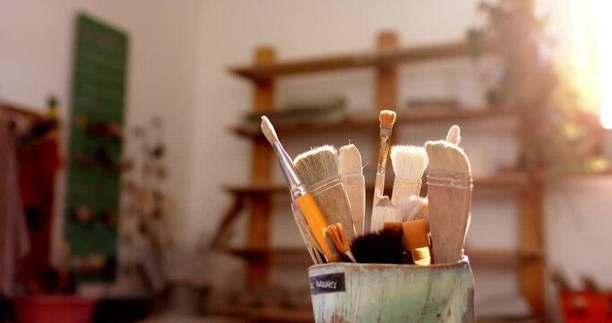 Box with pottery brushes on desk in pottery studio