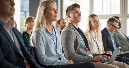 Young Female Psychologist Attending an International Cognitive Behavioral Therapy Seminar. Caucasian Woman Focused on Presenter. Psychotherapy Professional Sitting in Crowded Room on Training Program. - obrazy, fototapety, plakaty