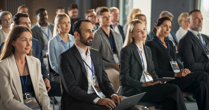 Diverse Biopharma Entrepreneurs Sitting In Crowd At International Medical Summit, Using Laptops, Tablets To Take Notes. Male And Female Industry Leaders Listening To Presentation About Biotechnology.