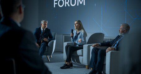 International Technology Conference: Male Host Asking Caucasian Female CEO a Question In Front Of Audience. Confident Woman Delivering Inspirational Speech And Diverse Attendees Listening Carefully.
