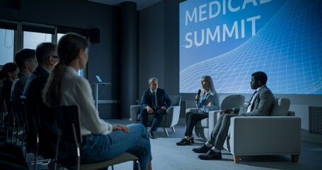 International Medical Summit: Host Asking Caucasian Female Pharmaceutical CEO a Question In Front Of Audience Of Diverse Attendees. Woman Talking About New Developments In Biotechnology, Medicine. - obrazy, fototapety, plakaty