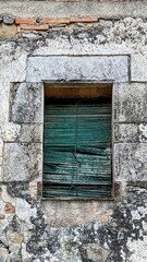 Close-up of an aged green shutter on a vintage building