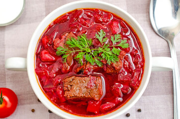 Borscht soup with vegetables and meat on a wooden table
