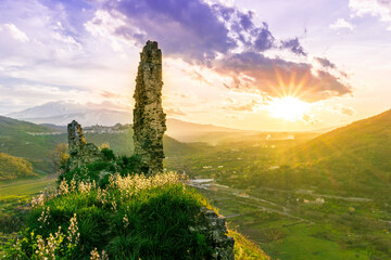 picturesque view from a mountain with ancient monument or castle ruins to a green valley with...