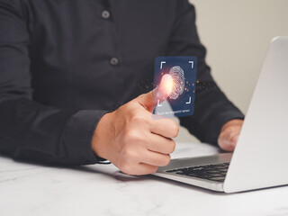 Businesswoman login to the system with a fingerprint on the virtual screen while sitting at the...