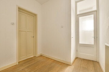 an empty room with white walls and wood flooring the door is open on the right side of the room