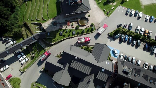 4k Bird Eye Shot of Fire Trucks Driving on Curvy Road between Buildings and Cars