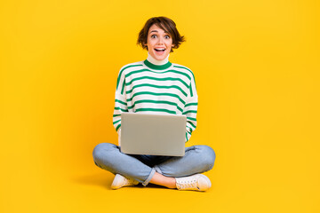 Full length photo of young surprised woman programmer reaction crazy artificial intelligence help laptop isolated on yellow background