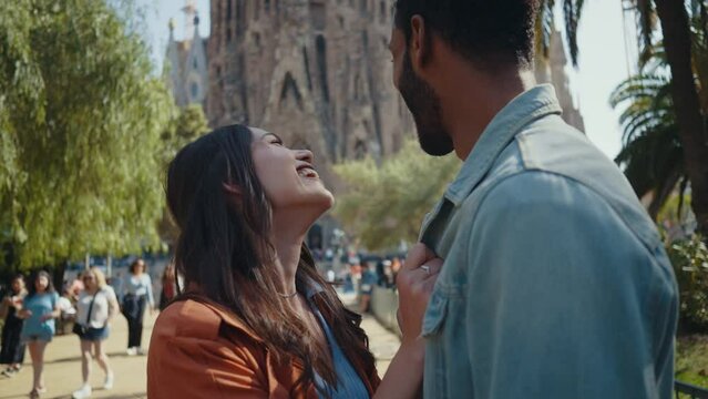 Young multiethnic couple visiting and dating in the center of Barcelona. Travelers on vacation exploring the city and the main landmarks and famous places