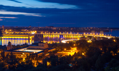 Evening view of Dneproges dam with hydroelectric power station illuminated in blue and yellow colors, Dnieper river, Zaporizhzhia, Ukraine