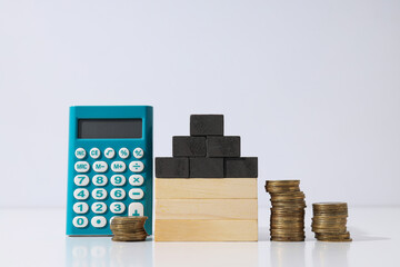 Wooden model of a house with a calculator, coins