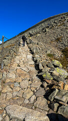 Fototapeta na wymiar Mountain hiking trail lined with stones in Poland, climbing Sniezka Mountain