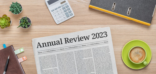 A newspaper on a desk with the headline Annual review 2023 - obrazy, fototapety, plakaty