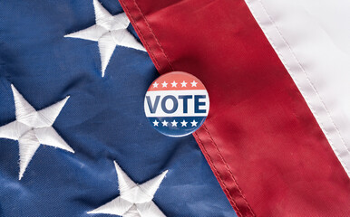 Closeup of american vote badges on national USA flag background, copy space, elections. US presidental election voting symbol