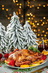 Baked Christmas duck with thyme, berry and orange served on a festive table. vertical image. top view. place for text