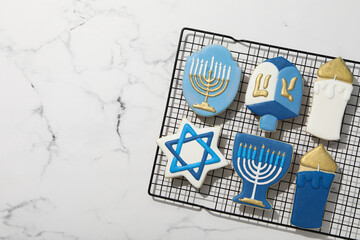 Gingerbread cookies with Jewish signs on marble background, space for text