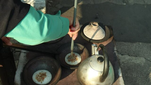 Lift the cooked serabi from the clay pot, Serabi is a typical Sundanese food like pancakes but has a savory taste.
