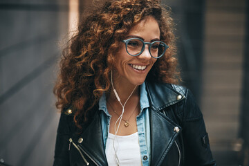 Smiling young woman listening to music on an metro escalator