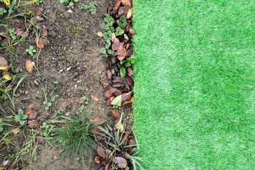 A section of vibrant green artificial grass has been laid next to an uncovered soil area that has...