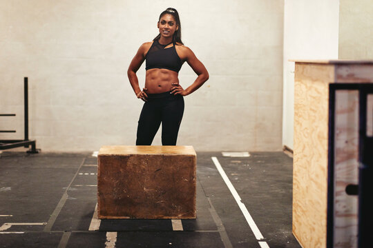 Smiling woman ready for a gym box jump class