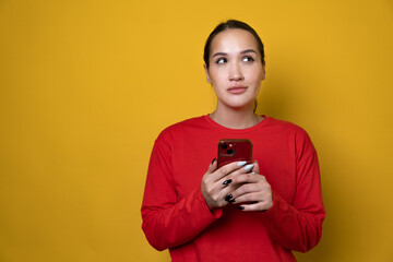 Portrait of attractive cheerful girl using device gadget app smm post isolated over bright yellow color background