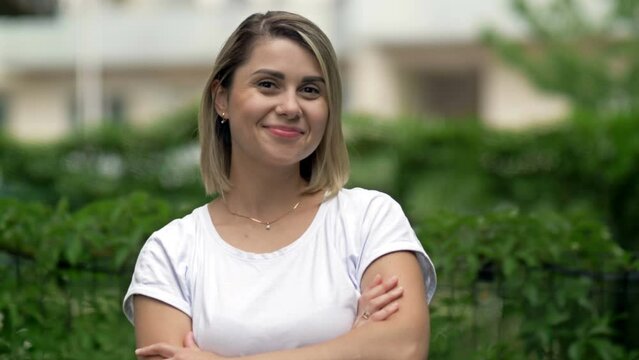 Portrait of a smiling young woman on the background of summer greenery.