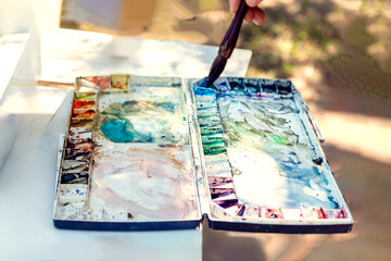 watercolour palette on a table in the countryside