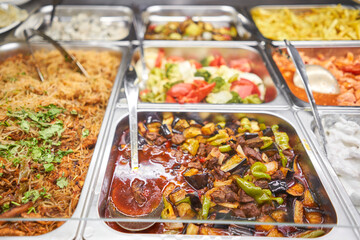 Various hot dishes . Glass Showcase in a buffet or self-service restaurant.