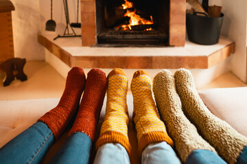 Closeup legs of women wearing warm socks in front of fireplace - Winter season concept
