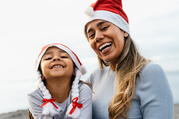 Happy Latin mother with her daughter enjoying Christmas holidays - Family and holidays concept