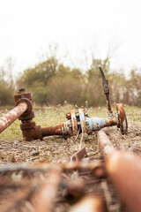 Old rusty metal gas pipe, left on a field, abandoned pipeline. 