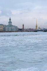 Beautiful winter cityscape. Historic city center of St. Petersburg, Russia. View of the building of the Kunstkamera, the rostral column and the Peter and Paul Cathedral. Ice floes on the Neva River.