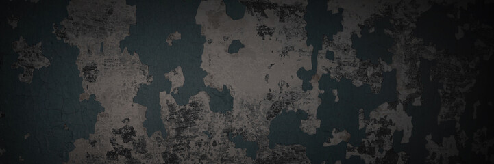 Dark wide panoramic background. Peeling paint on a concrete wall. Dark grunge texture of old cracked flaking paint. Weathered rough painted surface. Patterns of cracks. Darkness background for design.
