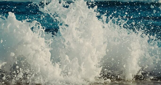 Close up abstract view of ocean wave crashing into the shoreline in slow motion, 10000 fps